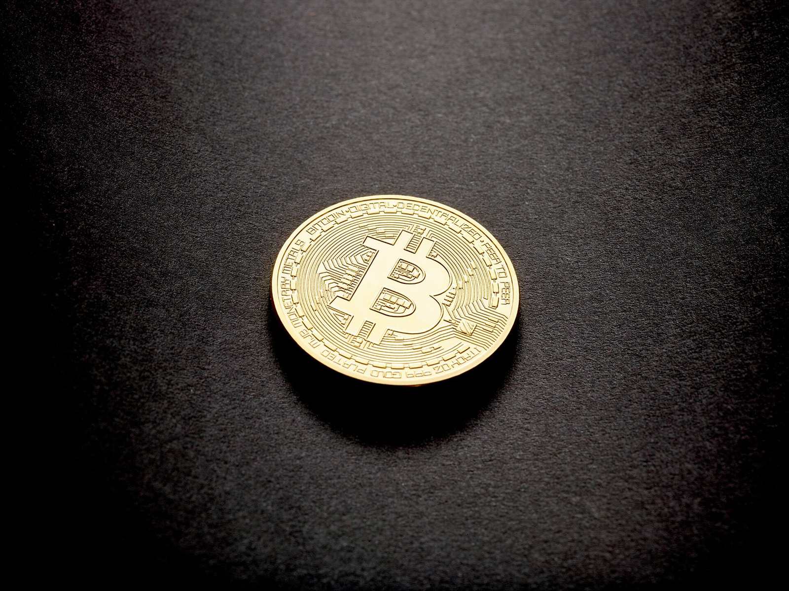 Een bitcoin-munt op een donkere ondergrond